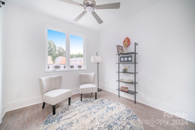 living area with wood-type flooring and ceiling fan