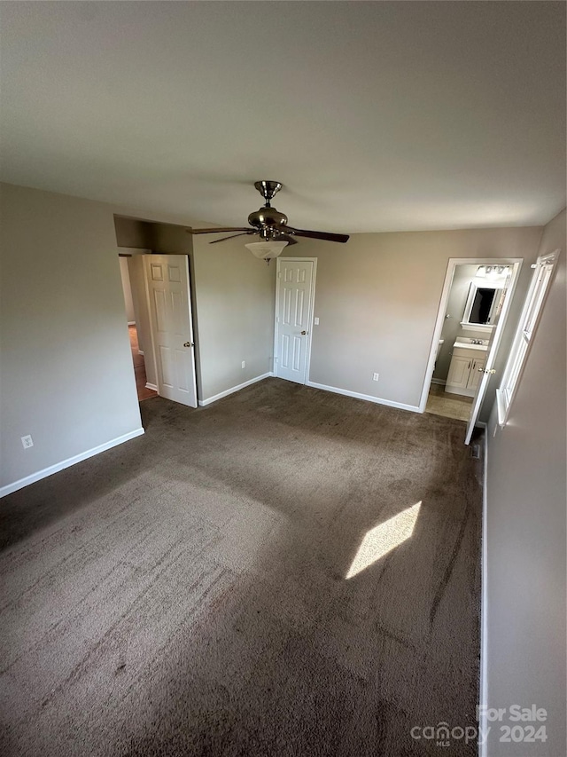 unfurnished living room featuring ceiling fan and dark carpet