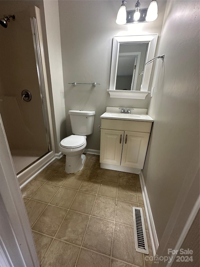 bathroom featuring tile patterned floors, vanity, toilet, and an enclosed shower