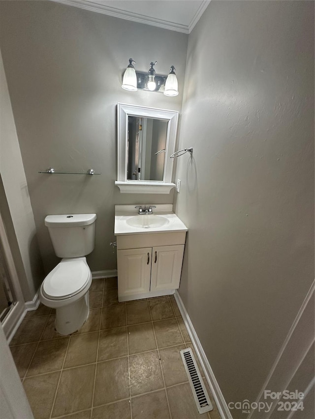 bathroom featuring tile patterned flooring, vanity, toilet, and ornamental molding