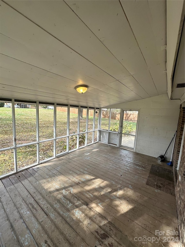 unfurnished sunroom featuring vaulted ceiling