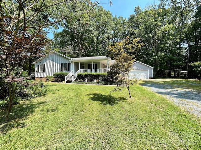 single story home with an outbuilding, a front yard, a porch, and a garage