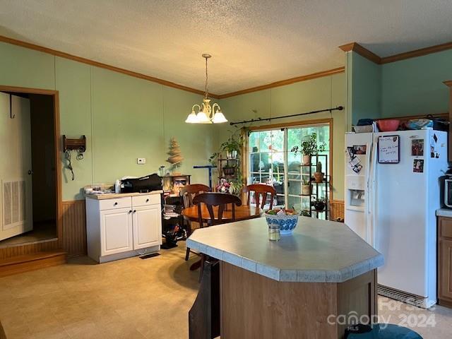 kitchen with a textured ceiling, light tile patterned floors, a center island, an inviting chandelier, and white fridge with ice dispenser