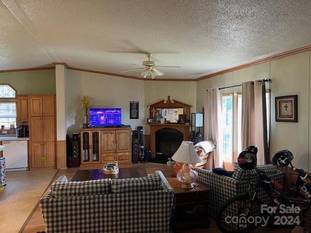 living room with a textured ceiling, crown molding, ceiling fan, and light hardwood / wood-style floors