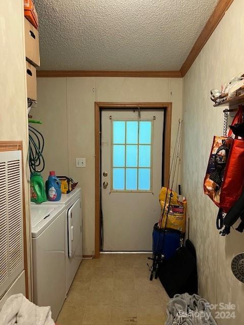 laundry room featuring independent washer and dryer, light tile patterned floors, a textured ceiling, and crown molding