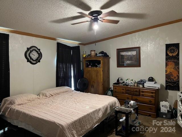 bedroom with ceiling fan, a textured ceiling, and carpet floors