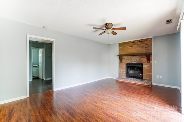 unfurnished living room featuring hardwood / wood-style flooring, a brick fireplace, and ceiling fan