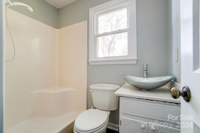 bathroom with toilet, a wealth of natural light, and vanity