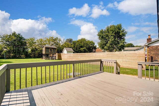 deck featuring an outdoor structure and a lawn