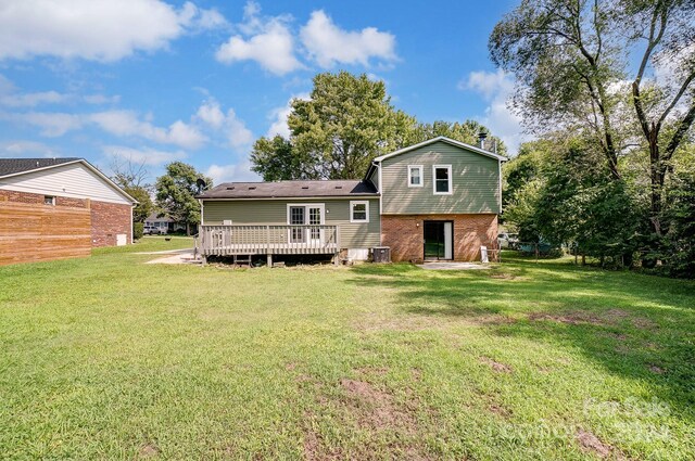 back of house featuring a wooden deck and a lawn