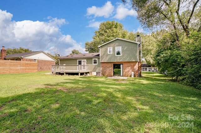 rear view of property with a deck and a yard