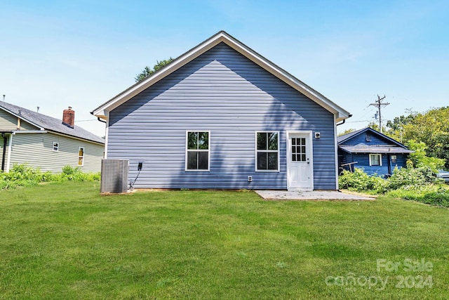 back of house featuring cooling unit and a yard