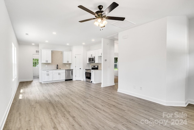 unfurnished living room featuring sink, ceiling fan, and light hardwood / wood-style flooring