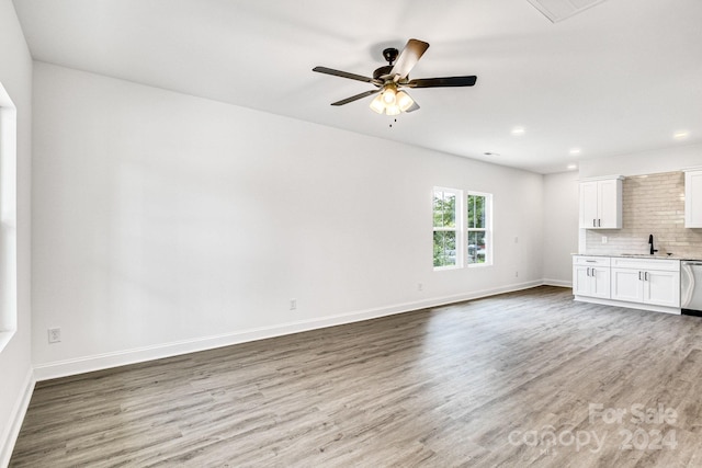 unfurnished living room featuring sink, hardwood / wood-style floors, and ceiling fan