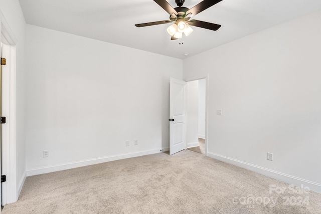 spare room featuring ceiling fan and light colored carpet