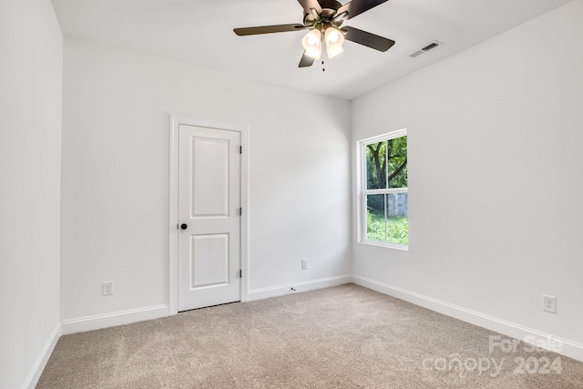 carpeted spare room with ceiling fan