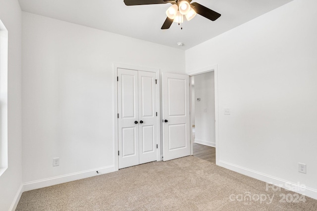 unfurnished bedroom with light carpet, a closet, and ceiling fan