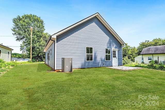 rear view of property with a lawn and a patio