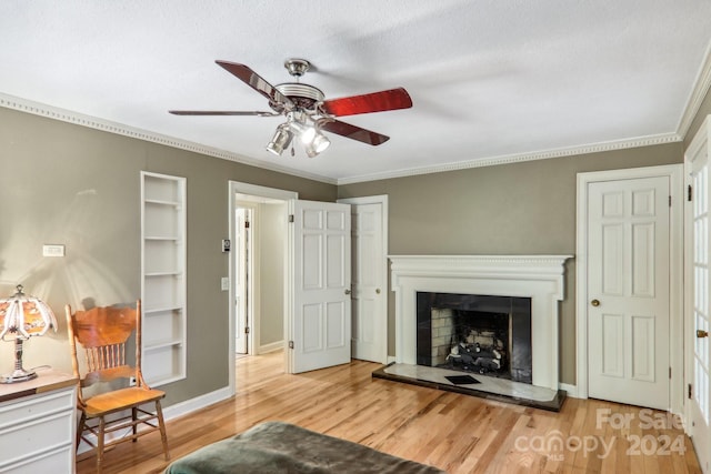 living room featuring a textured ceiling, ceiling fan, ornamental molding, and light wood-type flooring