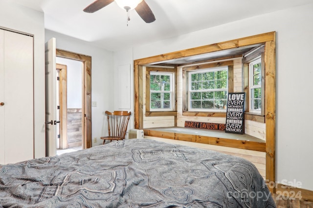 bedroom featuring ceiling fan, radiator, and a closet