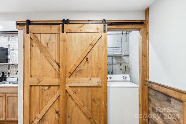 washroom with a barn door and washer / clothes dryer