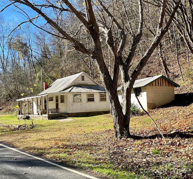 view of side of home with a lawn and covered porch