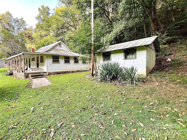 exterior space featuring an outdoor structure, a yard, and a porch