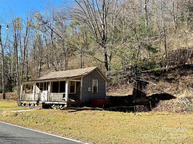 851 Lower Shut In Rd, Hot Springs, NC 28743 - view of front of home featuring covered porch, heating fuel, metal roof, a view of trees, and a front lawn
