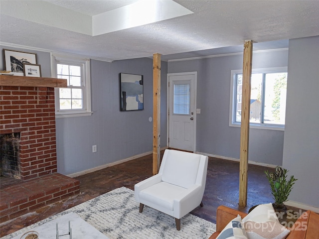 sitting room featuring a textured ceiling, a fireplace, and a healthy amount of sunlight