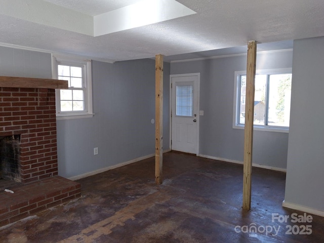 basement with a healthy amount of sunlight, a fireplace, and a textured ceiling