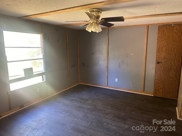 spare room featuring dark hardwood / wood-style flooring, a textured ceiling, and ceiling fan