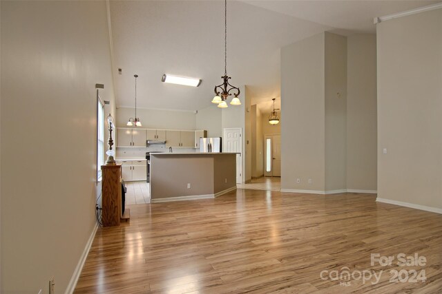 unfurnished living room featuring light tile patterned floors, an inviting chandelier, and a towering ceiling