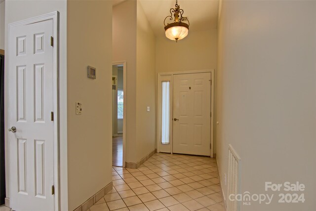 foyer entrance featuring light tile patterned flooring and a high ceiling