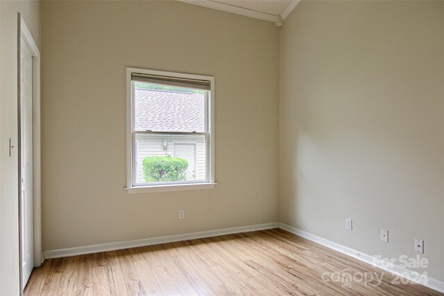 spare room featuring light hardwood / wood-style flooring and ornamental molding