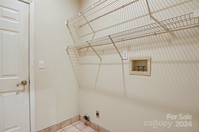 laundry area with hookup for an electric dryer, hookup for a washing machine, and tile patterned flooring