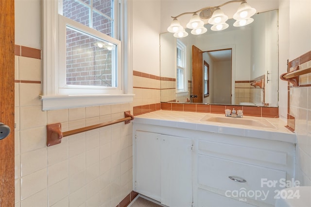 bathroom with tile walls, a wealth of natural light, and vanity