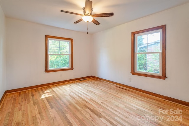 empty room with ceiling fan and light hardwood / wood-style flooring