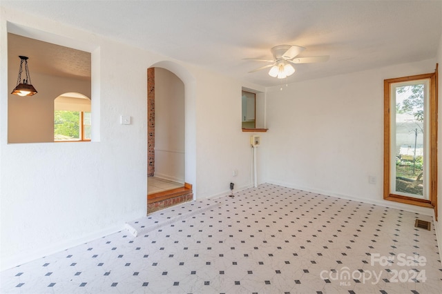 empty room featuring ceiling fan and tile patterned floors