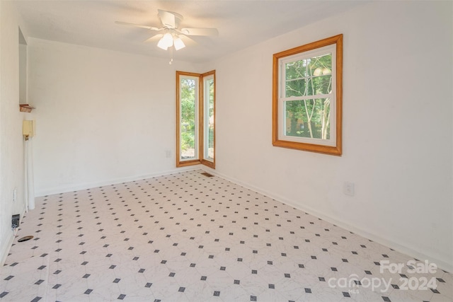 tiled empty room featuring ceiling fan