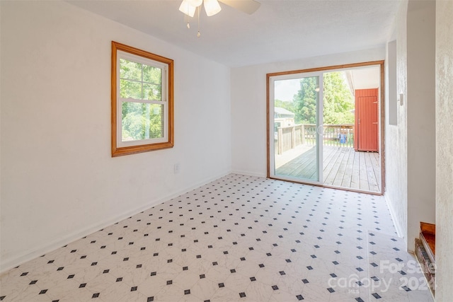 empty room featuring ceiling fan, plenty of natural light, and tile patterned flooring