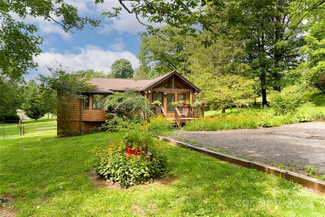 view of front of house featuring a wooden deck and a front yard