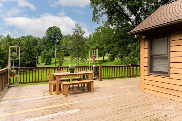 wooden terrace featuring a lawn