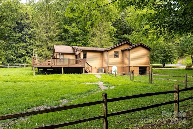 back of property with a yard, cooling unit, a deck, and a rural view