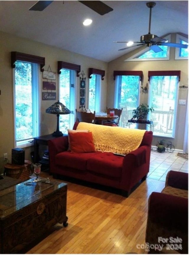 living room featuring vaulted ceiling, ceiling fan, and light wood-type flooring