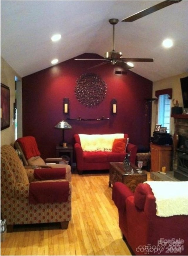 living room with lofted ceiling, ceiling fan, and light hardwood / wood-style flooring