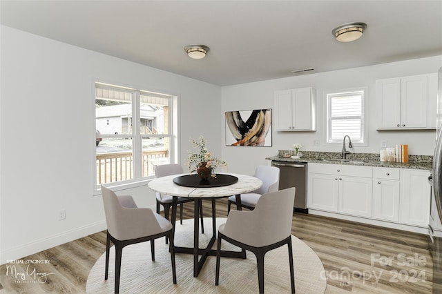 dining space featuring light wood-type flooring, baseboards, and visible vents