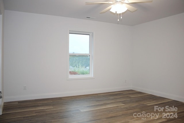 unfurnished room featuring ceiling fan, baseboards, dark wood-type flooring, and visible vents