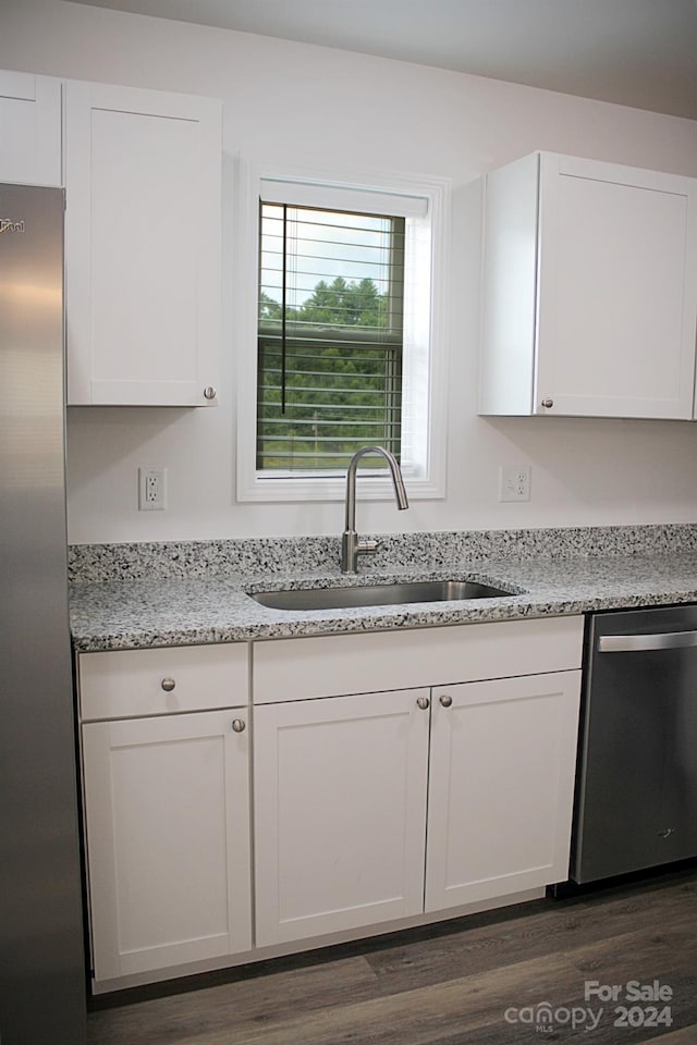 kitchen with dark hardwood / wood-style floors, stainless steel appliances, sink, and white cabinets