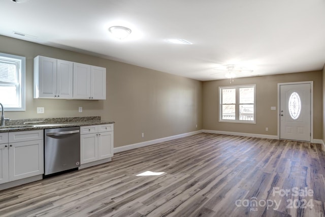 kitchen featuring light hardwood / wood-style flooring, white cabinets, ceiling fan, stainless steel dishwasher, and stone countertops