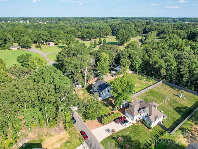 bird's eye view with a wooded view